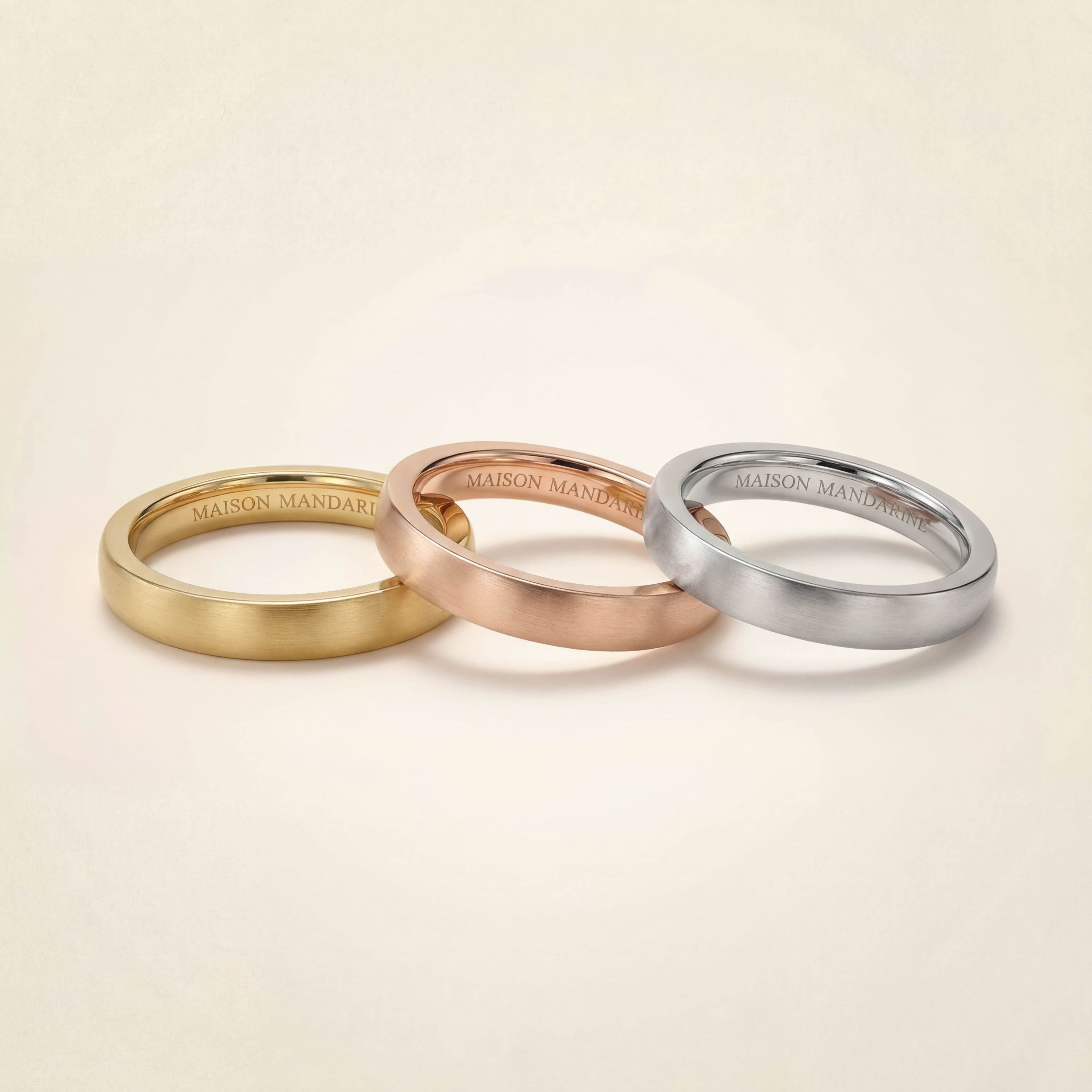 Alliances plates 2,5 mm en or jaune, or rose et or blanc 18 carats recyclé, finitions brossées mates, bagues Maison Mandarine sur fond ivoire.